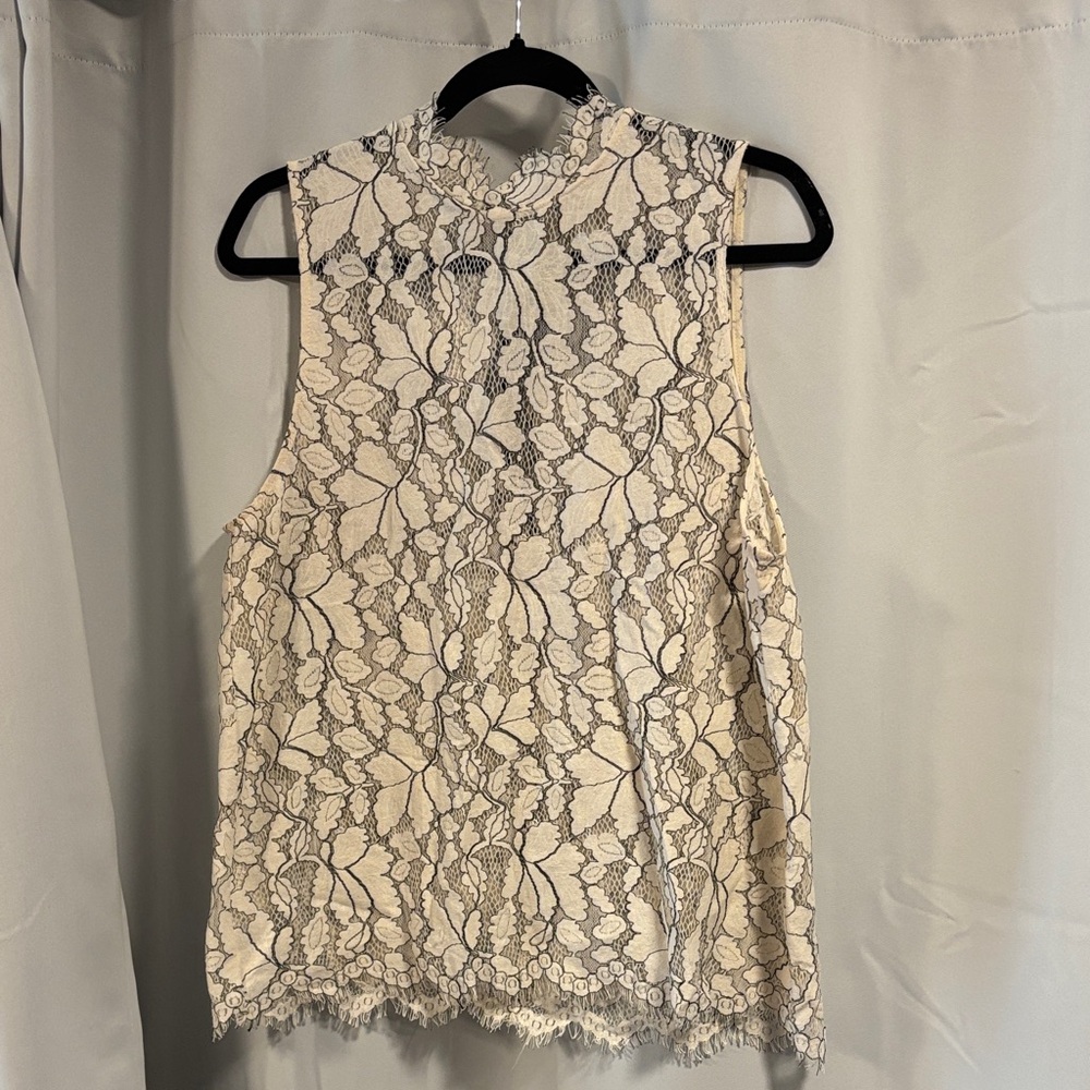 Elegant Lace Sleeveless Top - Cream with black stitching.